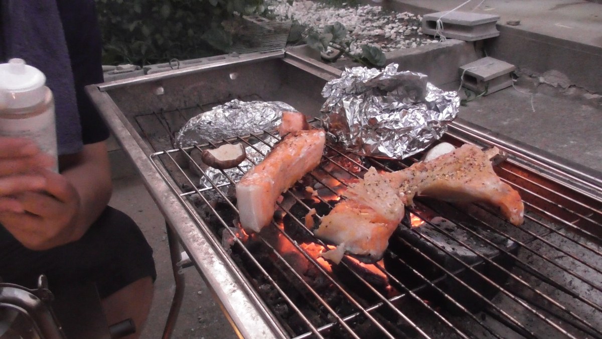 焼いている秋鮭にスパイスをふる