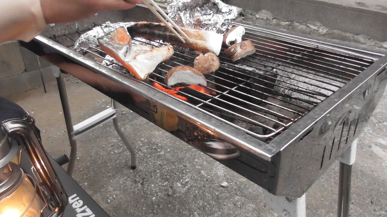 トングで秋鮭を返す