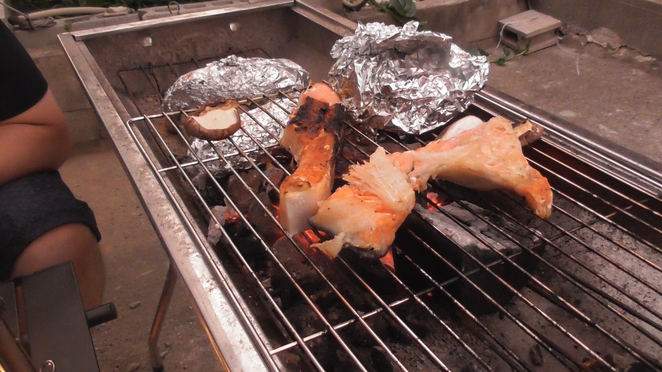 炭火の網で焼く秋鮭の切り身