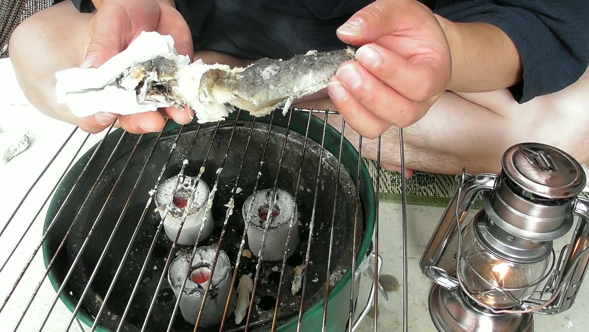 焼けた鮎を手で持って食べているところ
