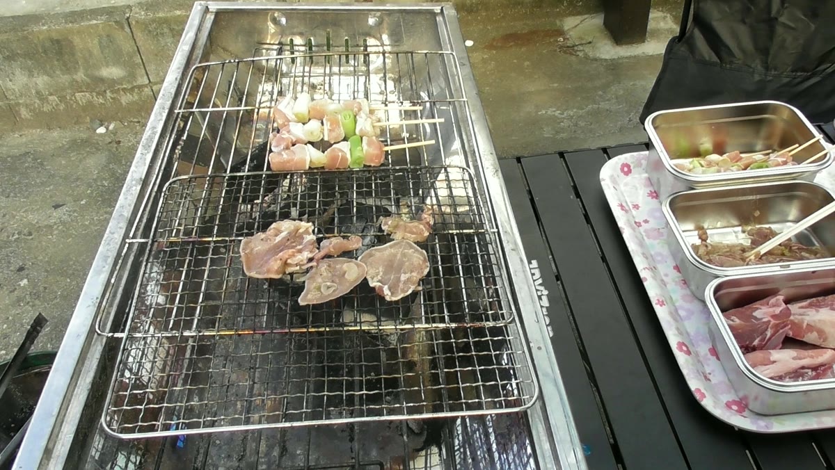 炭火の網に並べた豚タンと焼き鳥