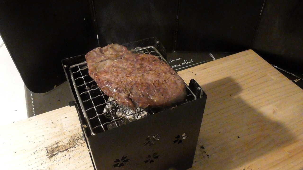 網の上で裏返したシャトーブリアン。上になった面に焼き色がついている。網の下に炭が見える