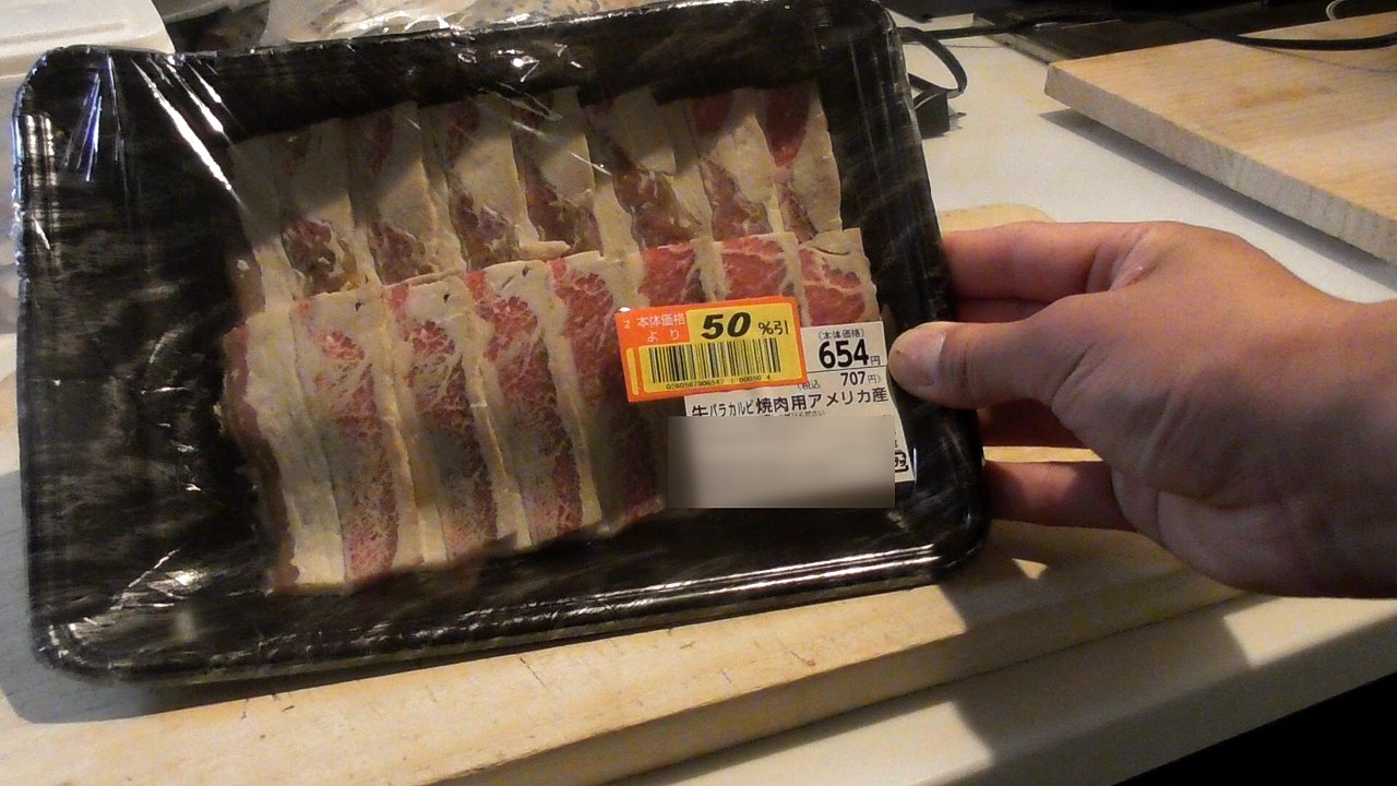 「50%引」のシールが貼られた牛バラカルビ焼肉用のパック。値札の下の行はぼかしている