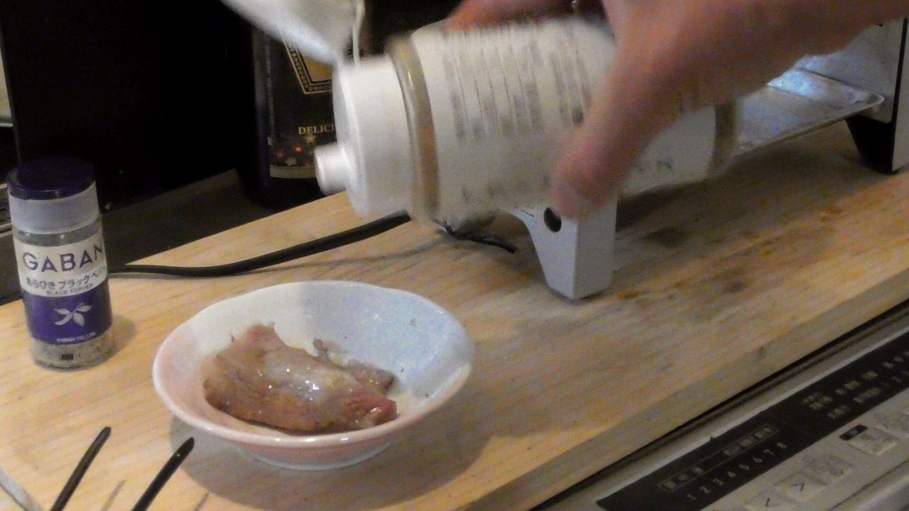 小皿の焼けたカルビに、ほりにしをかけているところ