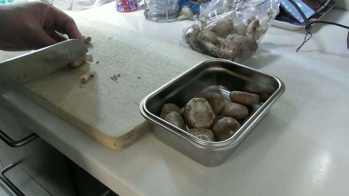 椎茸の軸を包丁で落としているところ