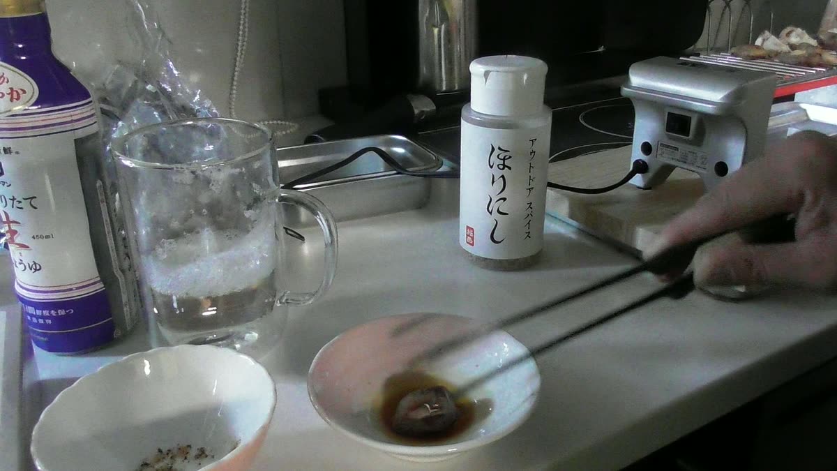 焼いた椎茸を醤油につけて食べる