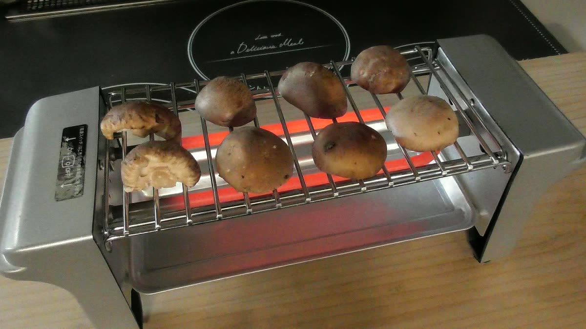 電気七輪の上で椎茸が焼けていくところ