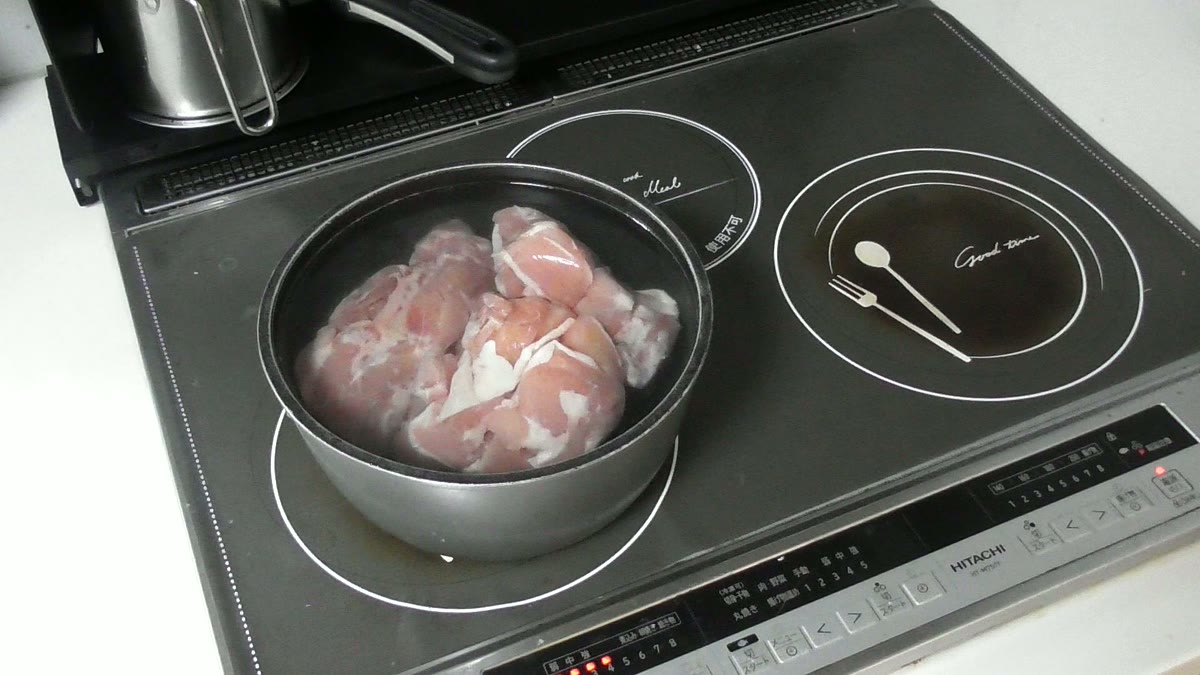 鍋に入れた生の鶏もも肉